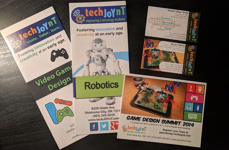 A spread of printed business cards, brochures, and event collateral